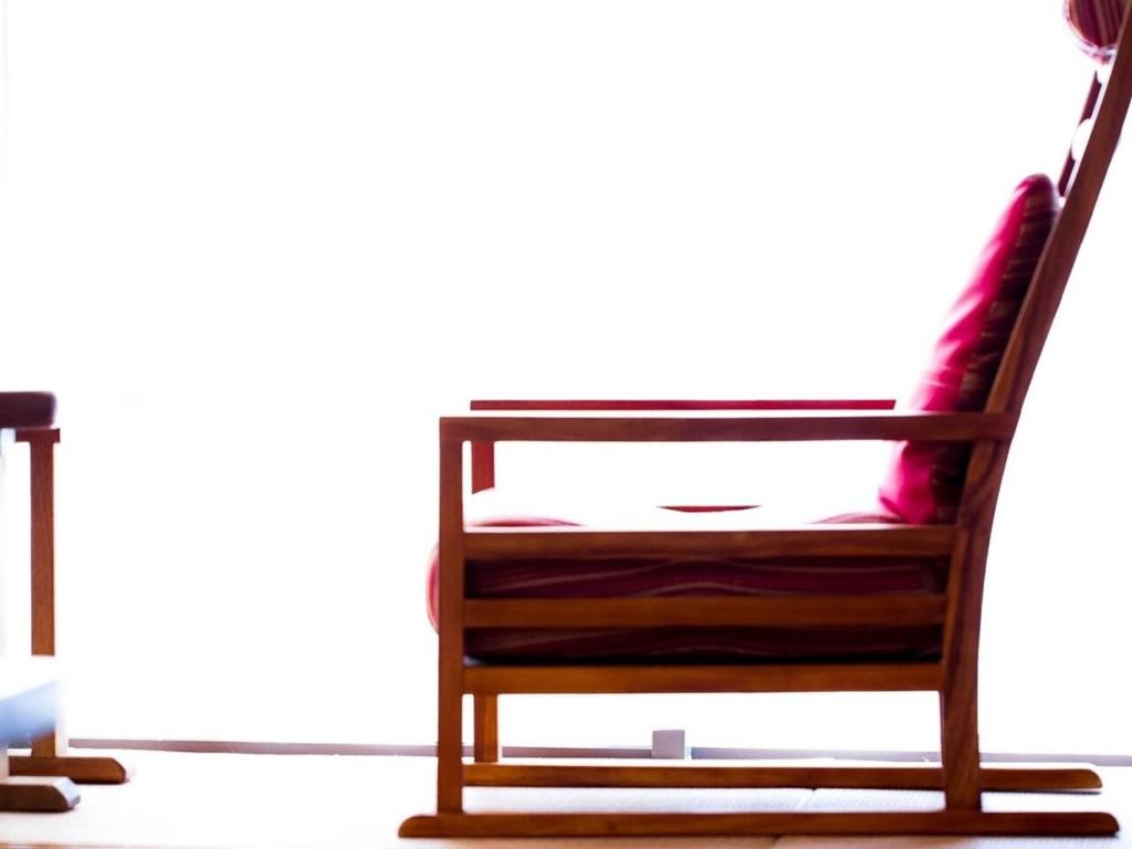 une chaise en bois avec un coussin rouge dessus dans l'établissement Yugawara Retreat Goen no Mori, à Yugawara