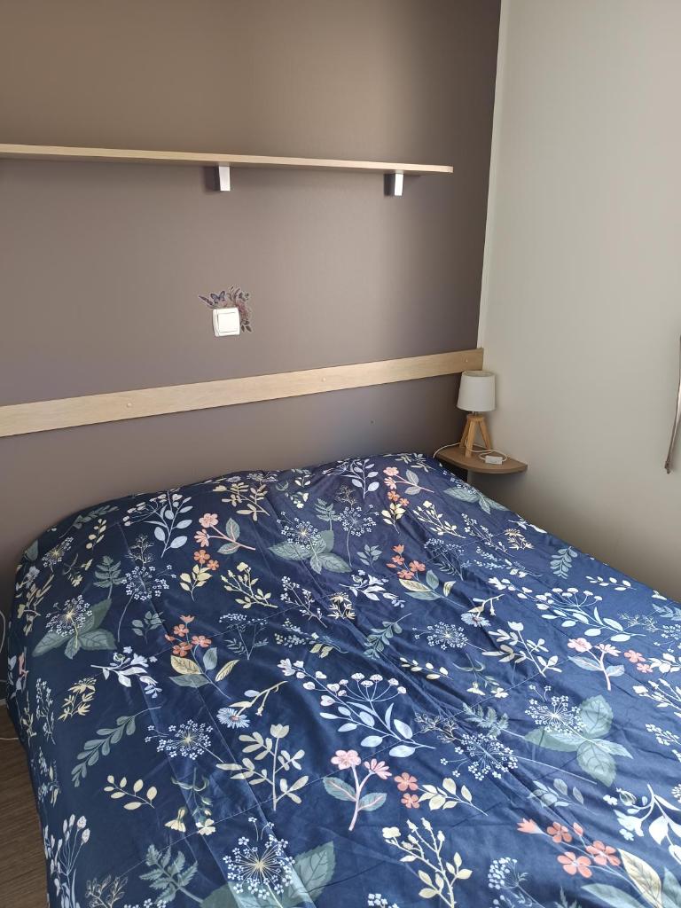 - un lit avec une couverture bleue et des fleurs dans l'établissement SABLE DU MIDI chez gégé, à Valras-Plage 26 autres photos