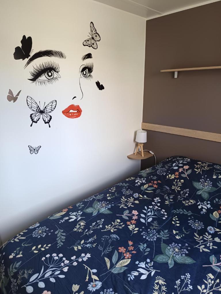 une chambre avec une fresque murale représentant une femme aux papillons dans l'établissement SABLE DU MIDI chez gégé, à Valras-Plage