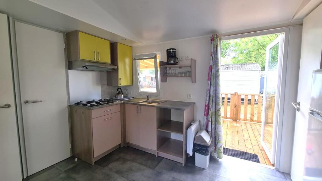 une petite cuisine avec un évier et une fenêtre dans l'établissement La Tranche sur Mer MH 3 Chbr 6 pers 430S, à Angles