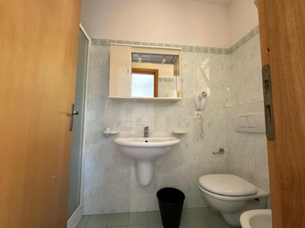 une salle de bain avec un lavabo, des toilettes et un miroir dans l'établissement Affittacamere Il Giardino, à Alba Adriatica