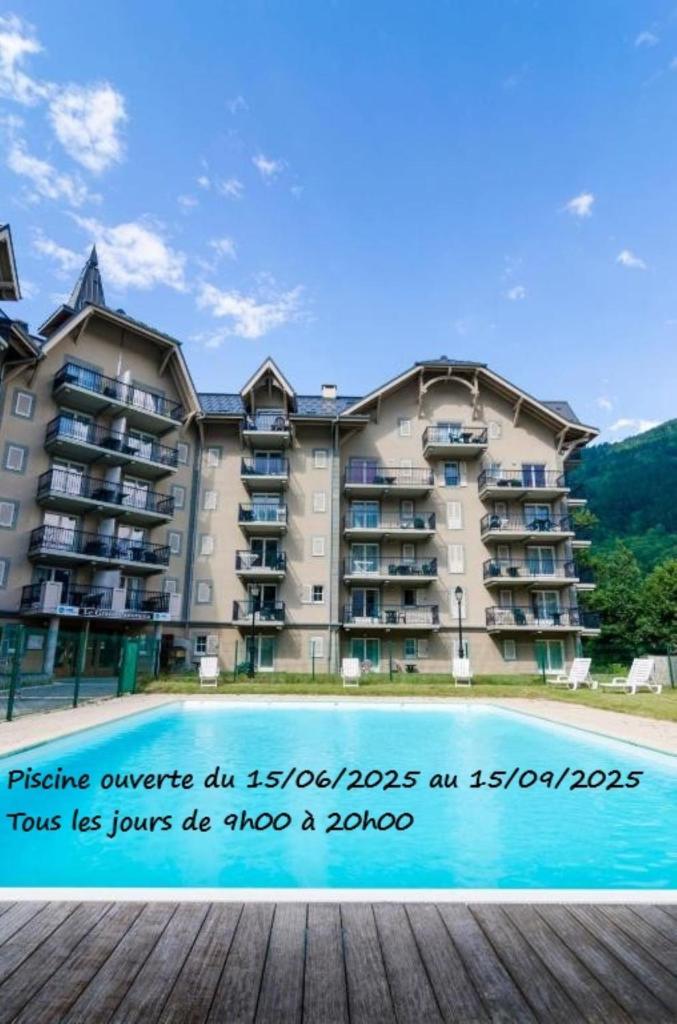 un grand bâtiment avec un panneau en face d'une piscine dans l'établissement Appartement T2+cabine indépendante au départ des télécabines Saint-Gervais/Bettex/Mont d’Arbois, à Saint-Gervais-les-Bains