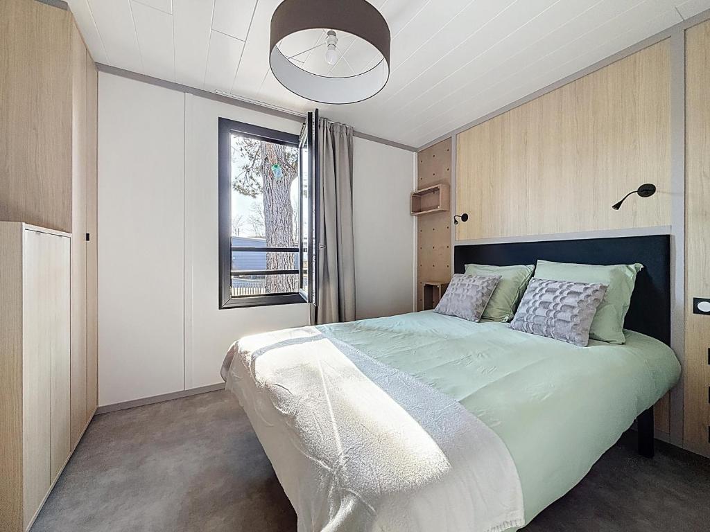 une chambre avec un grand lit et une fenêtre dans l'établissement La Criste Marine, à Jullouville