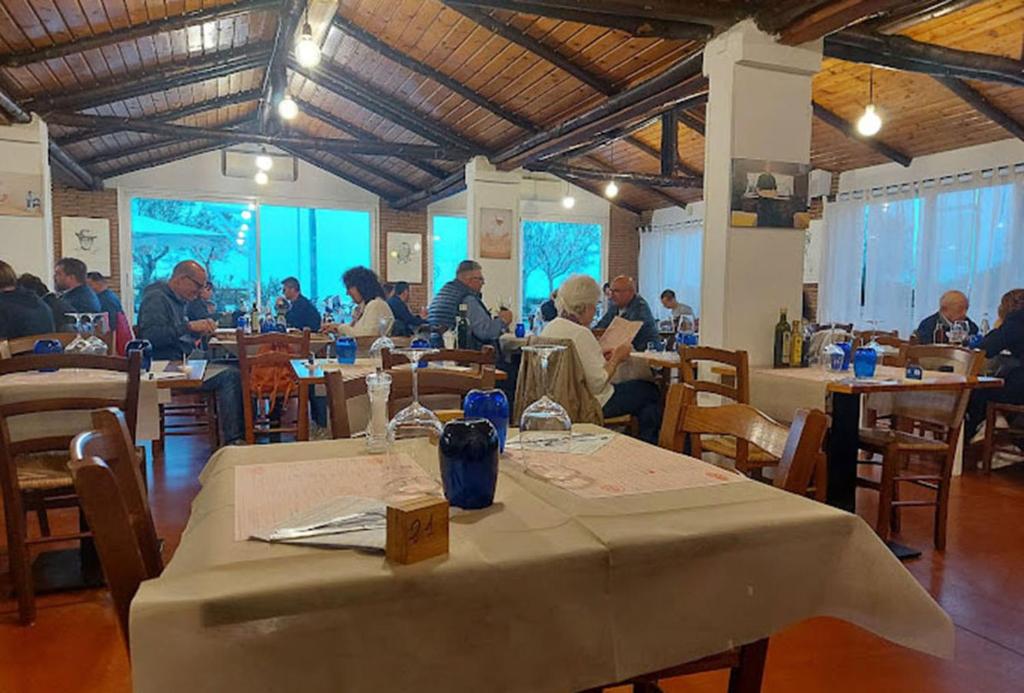 un groupe de personnes assises à des tables dans un restaurant dans l'établissement Hotel Remin Plaza, à Rimini