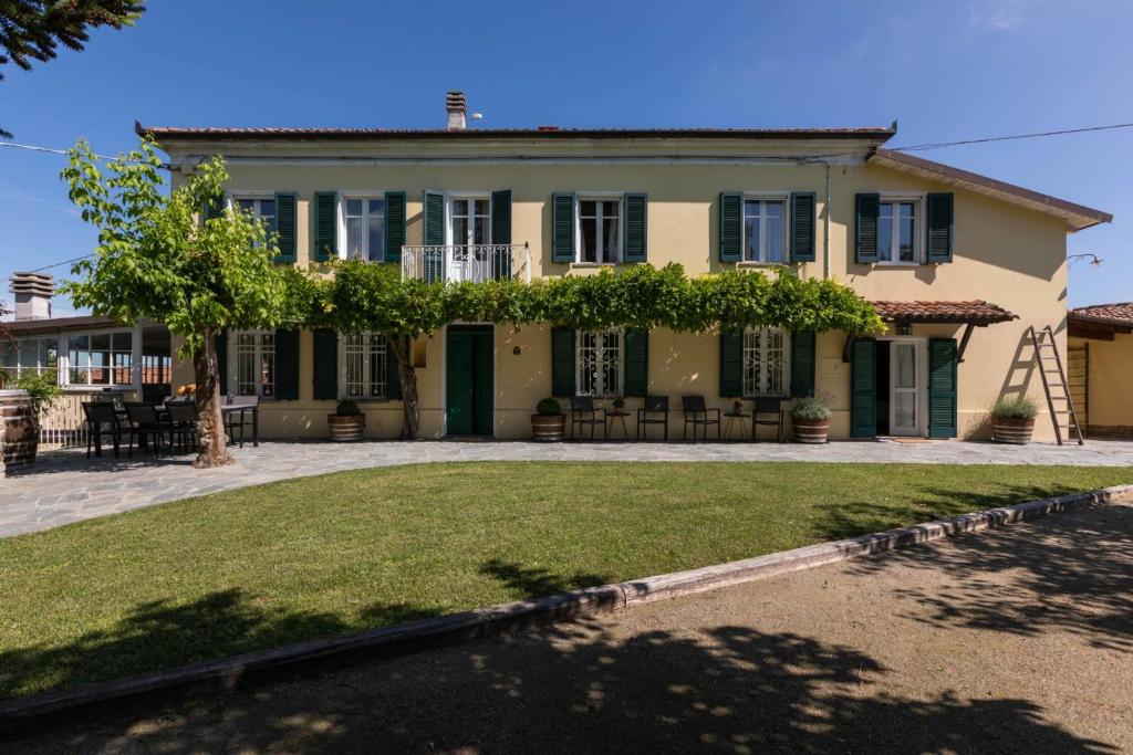 une grande maison avec une pelouse devant dans l'établissement Luxe Villa, All Ensuites & Private Vineyard Views, à San Marzano Oliveto