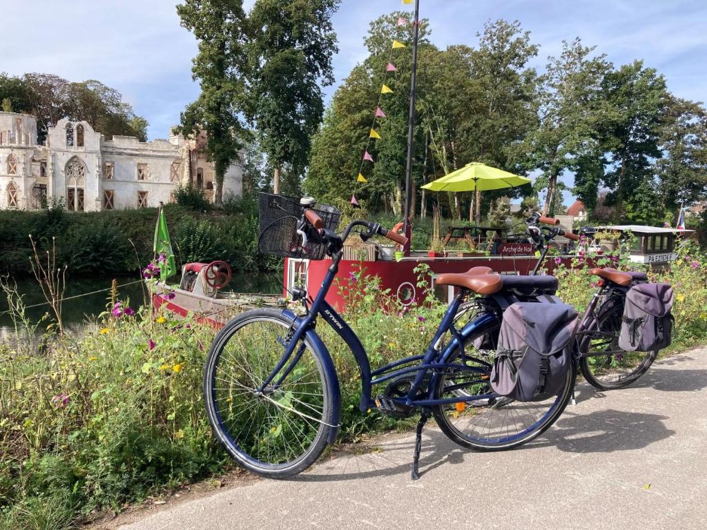 - deux vélos garés l'un à côté de l'autre dans un jardin dans l'établissement Sur la Somme à bord de la péniche Arche de Noé, à Pont-Rémy 4 autres photos