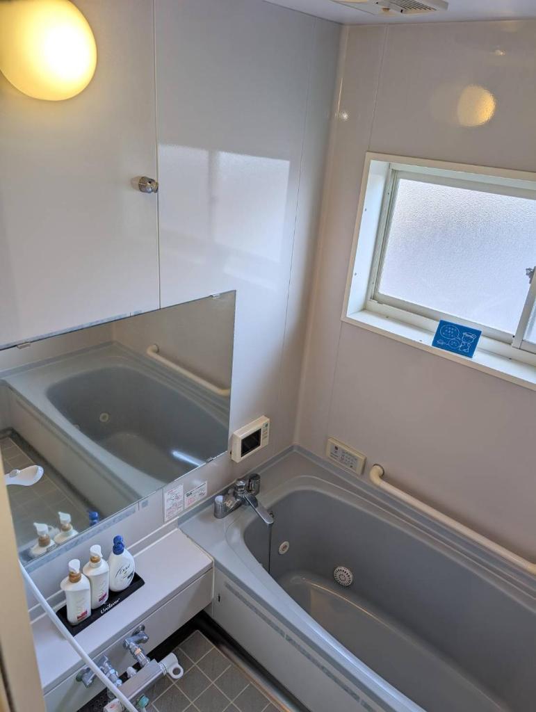 une salle de bain avec une baignoire et un lavabo dans l'établissement ホテル ツインビー, à Yabase