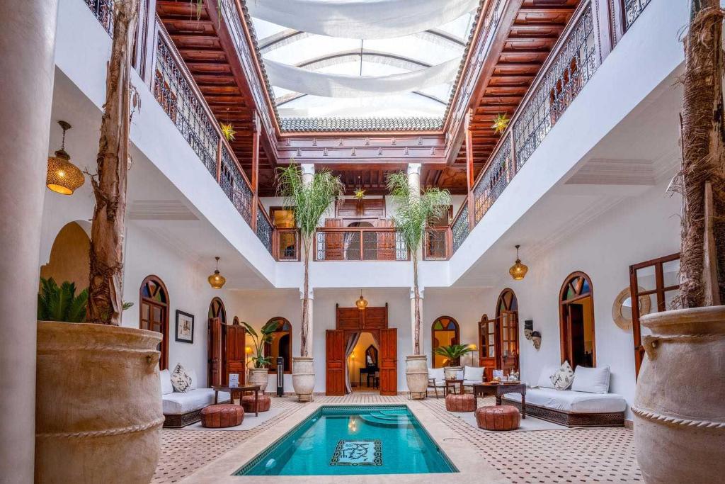 une grande chambre avec une piscine dans un bâtiment dans l'établissement Riad Adika & Spa, à Marrakech