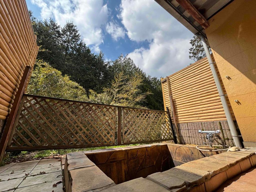 d'un balcon avec une clôture et des arbres en arrière-plan. dans l'établissement ホテル ひこうせん, à Yurihama