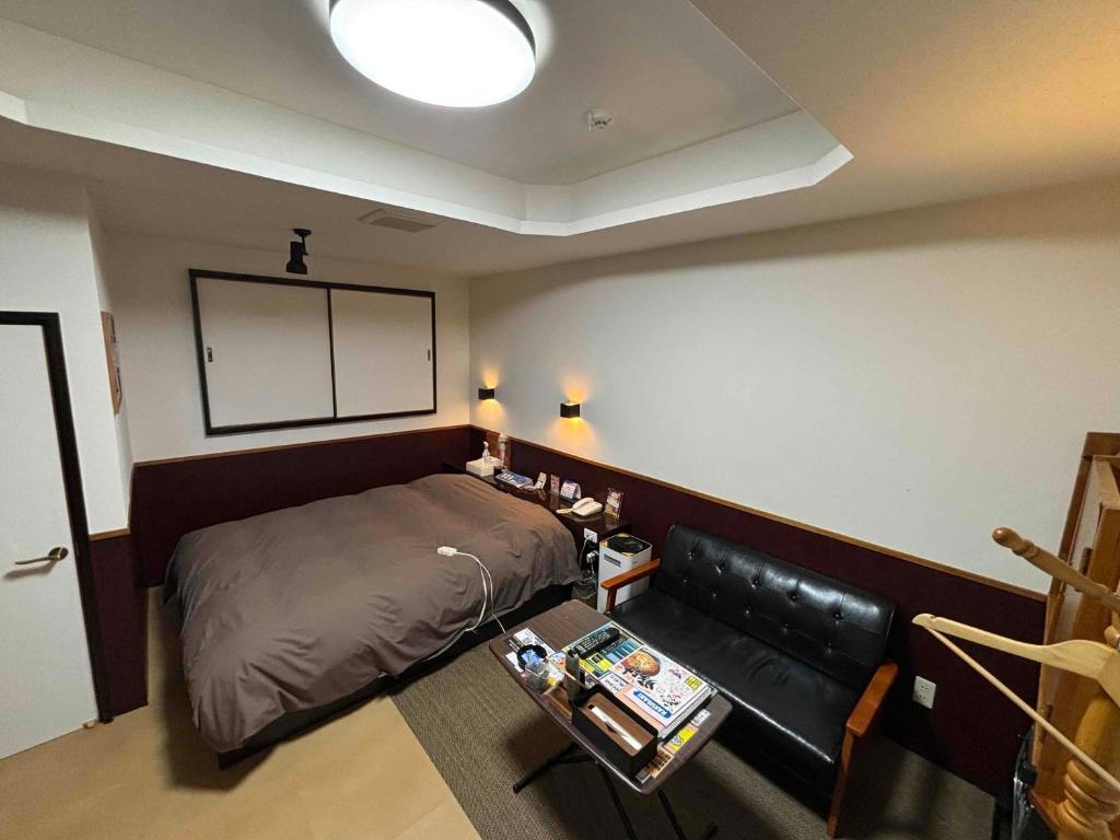 une chambre avec un lit et un canapé dans l'établissement ホテル ひこうせん, à Yurihama