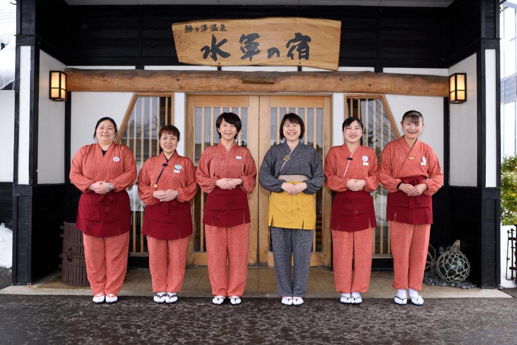 Un groupe de femmes debout devant un bâtiment dans l'établissement Suigunnoyado, à Ajigasawa
