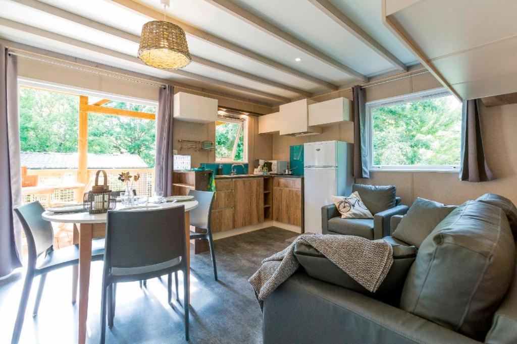 un salon avec un canapé et une table et une cuisine dans l'établissement Camping le Marache, à Biganos