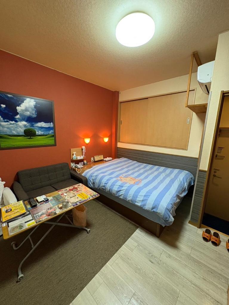 une chambre avec un lit, un canapé et une table dans l'établissement ホテル キラリ, à Tottori