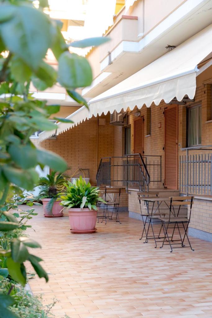 un patio extérieur avec tables, chaises et plantes dans l'établissement Affittacamere Il Giardino, à Alba Adriatica