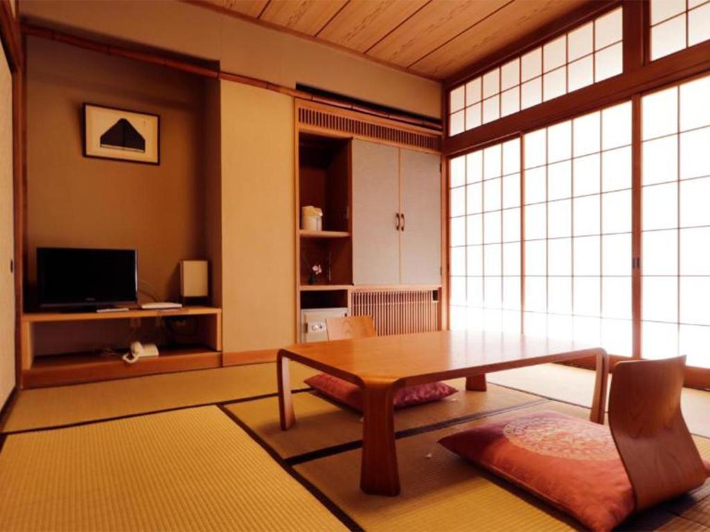un salon avec une table et une grande fenêtre dans l'établissement Wakaki Ryokan - Nasu Yumoto Onsen, à Nasu