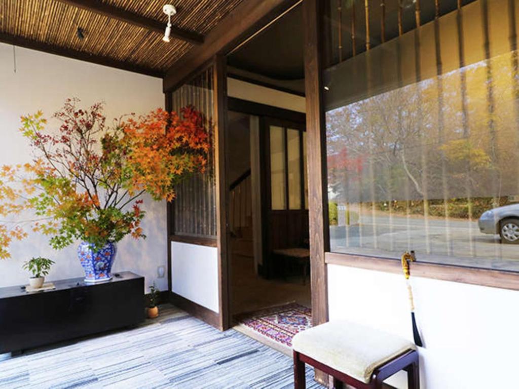 une terrasse couverte d'une maison avec une chaise et une fenêtre dans l'établissement Wakaki Ryokan - Nasu Yumoto Onsen, à Nasu