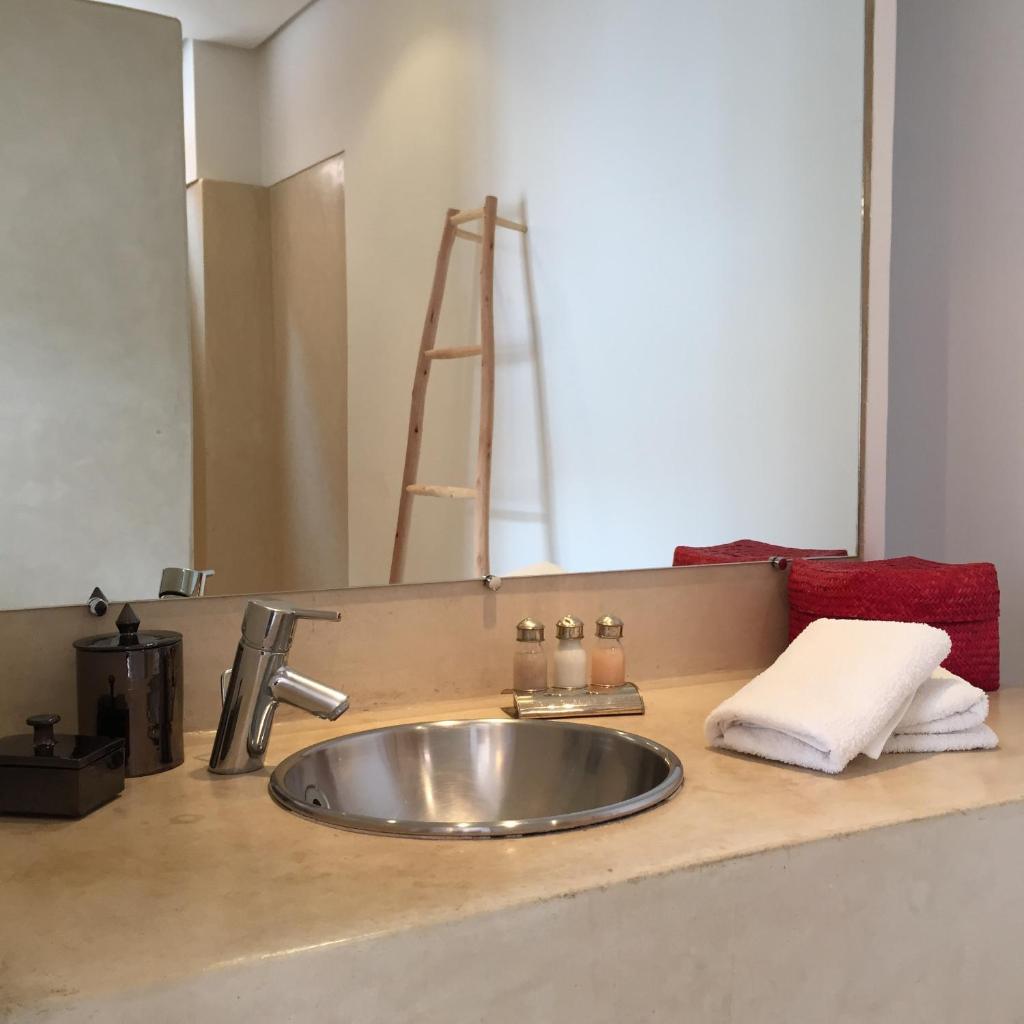 La salle de bains est pourvue d'un lavabo, d'une serviette et d'un miroir. dans l'établissement Riad UP, à Marrakech