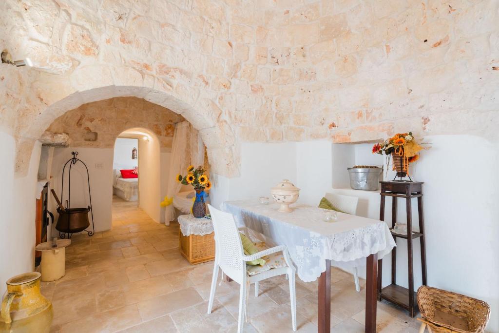 une salle à manger avec une table et un mur en pierre dans l'établissement Trullo Gazebo - Salento Selection, à Ceglie Messapica