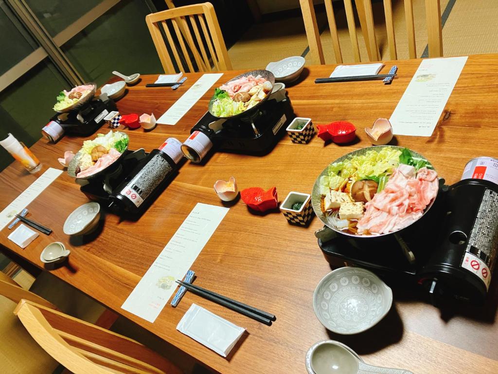 une table en bois avec trois bols de nourriture dans l'établissement YUPOPPO Hakone, à Hakone