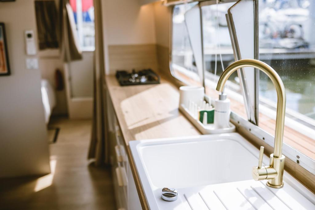 une cuisine avec un évier et une fenêtre dans l'établissement NIGHTBOAT Péniche, à Bordeaux