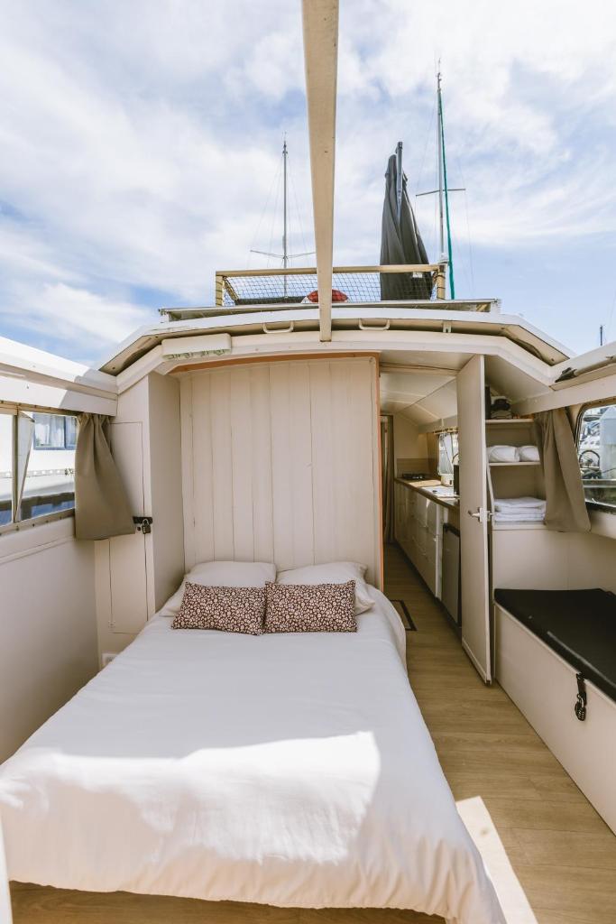 un lit à l'arrière d'un yacht dans l'établissement NIGHTBOAT Péniche, à Bordeaux