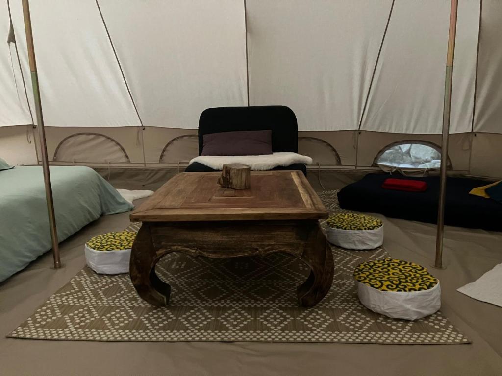 une chambre avec une table et une chaise dans une tente dans l'établissement Grande Tente Tipi en pleine forêt, à Burzet