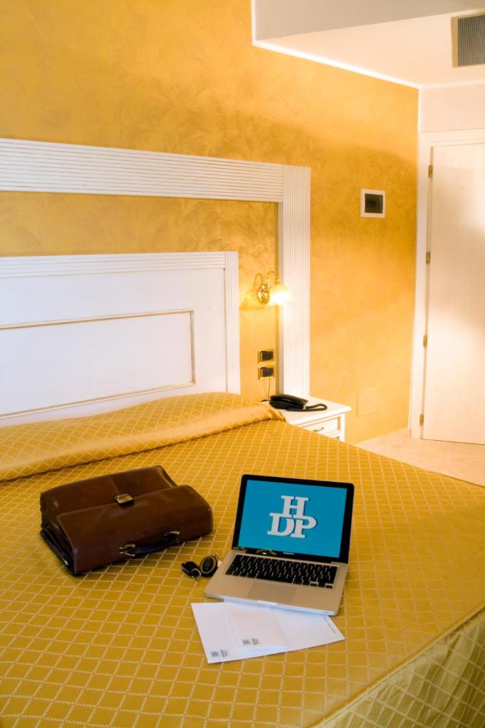 un ordinateur portable posé sur un lit dans l'établissement Hotel Diplomat Palace, à Rimini