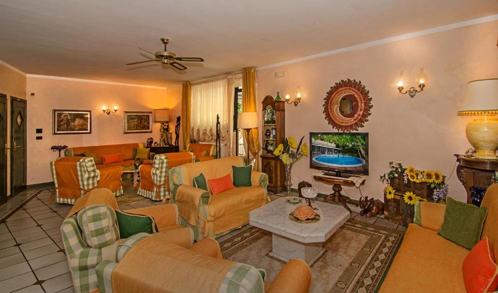 Il comprend un salon doté de meubles et d'une télévision. dans l'établissement Hotel Kyrton, à Forte dei Marmi