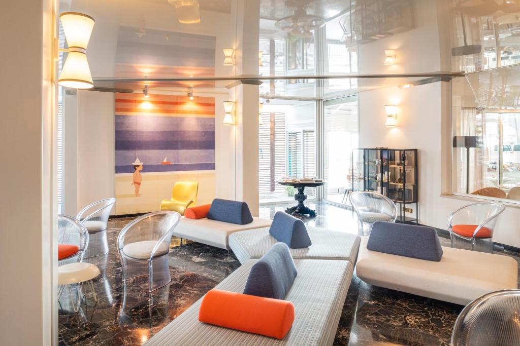 - un salon avec des canapés et des chaises dans un bâtiment dans l'établissement Hotel Delle Nazioni, à Lido di Jesolo