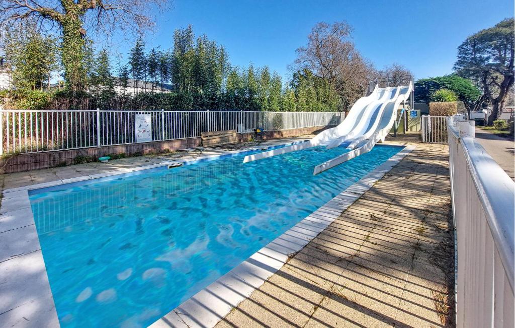 une grande piscine avec un toboggan blanc dans l'établissement Mobilhome With Shared Pool, à Carnac