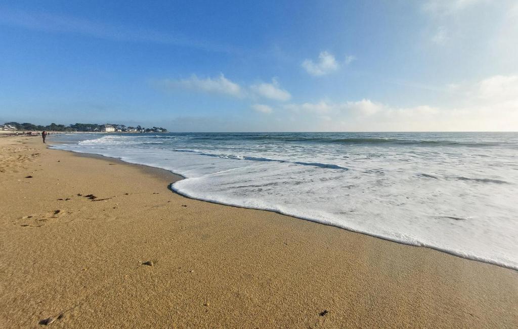 une plage avec l'océan et des empreintes sur le sable dans l'établissement Mobilhome With Shared Pool, à Carnac 11 autres photos