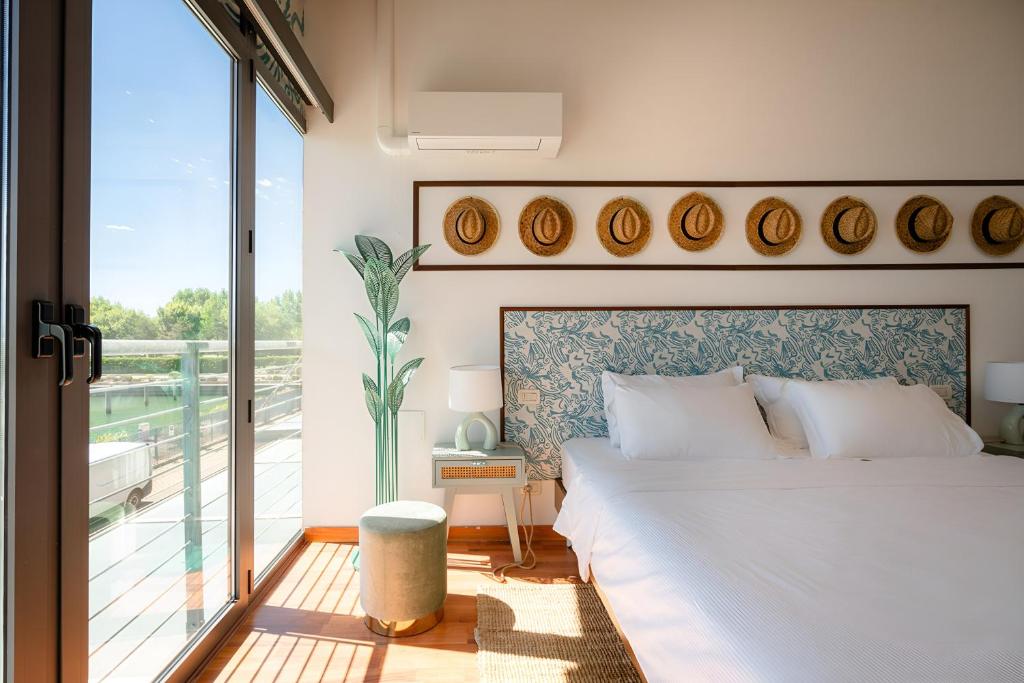 une chambre avec un grand lit et un balcon dans l'établissement HOTIDAY Room Collection - Grado, à Grado