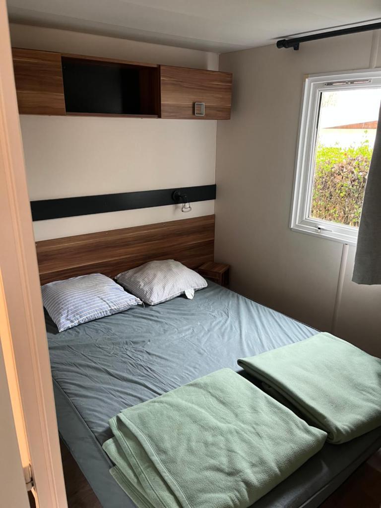 une petite chambre avec un lit et une fenêtre dans l'établissement Charmant Mobil home 6 places, à Carnac