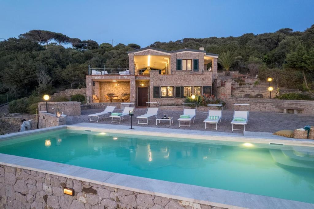une villa avec piscine devant une maison dans l'établissement Villa Coral Bay, à Alghero