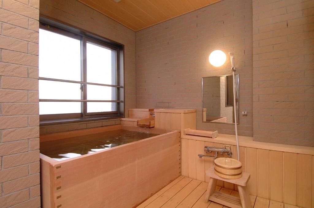 une salle de bain avec toilettes, lavabo et fenêtre dans l'établissement Yunohama Hotel, à Hakodate