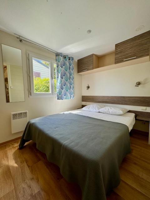 une chambre avec un grand lit avec une couverture bleue dans l'établissement CAMPING GINASSERVIS Mobile-home Flores, à Ginasservis