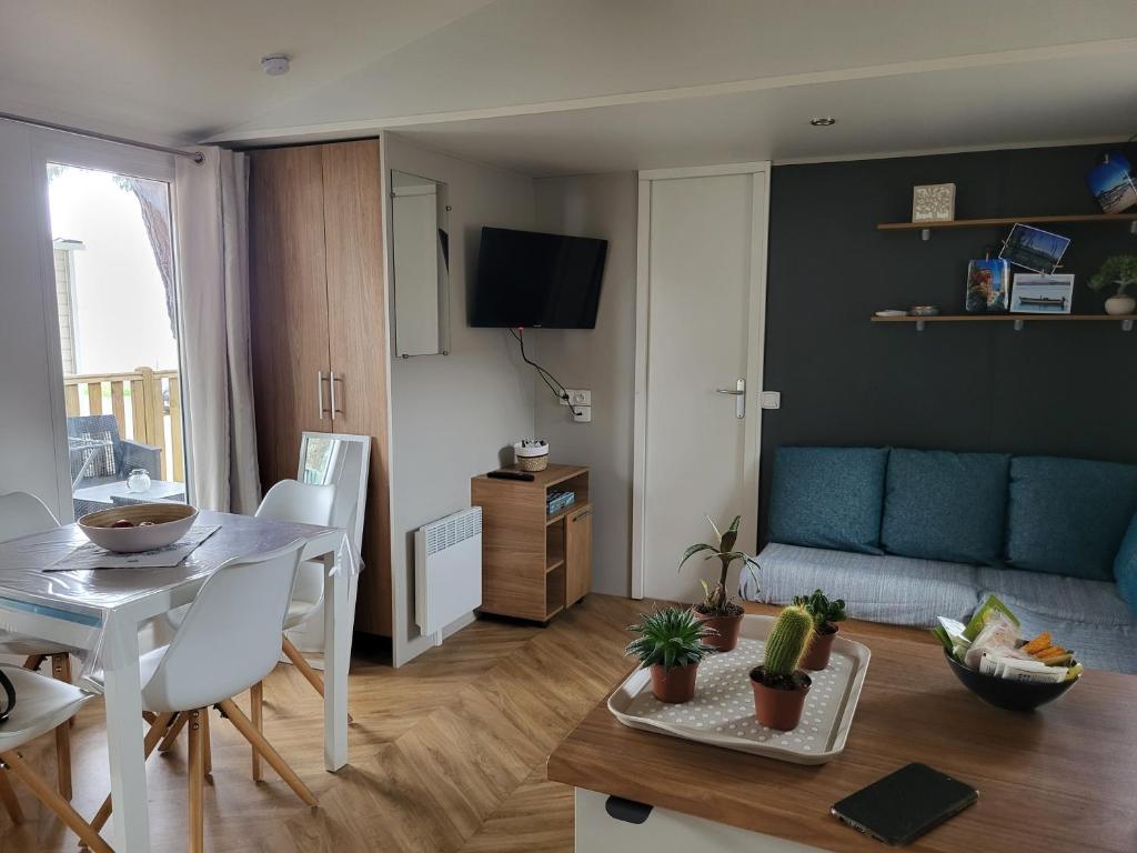 un salon avec une table et un canapé dans l'établissement Mobil Home spacieux Camping Mar Estang 4*, à Canet