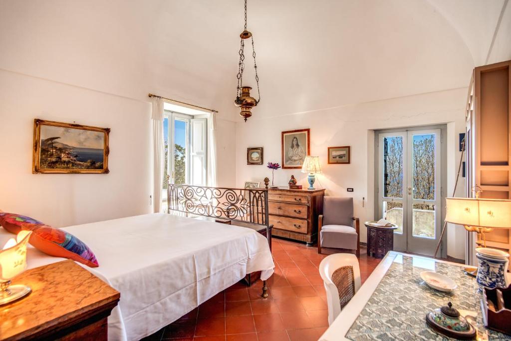 une chambre avec un lit et un bureau dans une pièce dans l'établissement Villa Monticello, private pool and timeless beauty, à Massa Lubrense