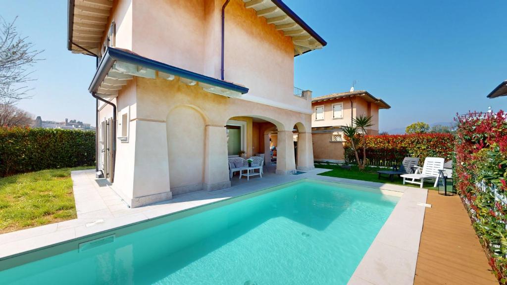 une villa avec piscine devant une maison dans l'établissement Villa Dolcevita by Bookinggardalake, à Manerba del Garda
