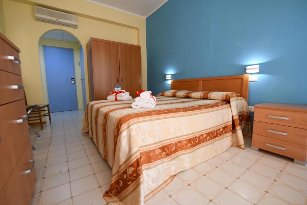 une chambre avec un grand lit avec des serviettes dessus dans l'établissement International Resort, à Mondragone 47 autres photos