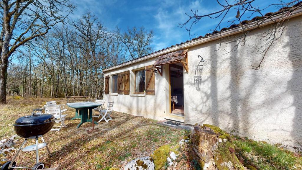 une petite maison avec un grill, une table et des chaises dans l'établissement Les Gîtes des Dryades, à Vers
