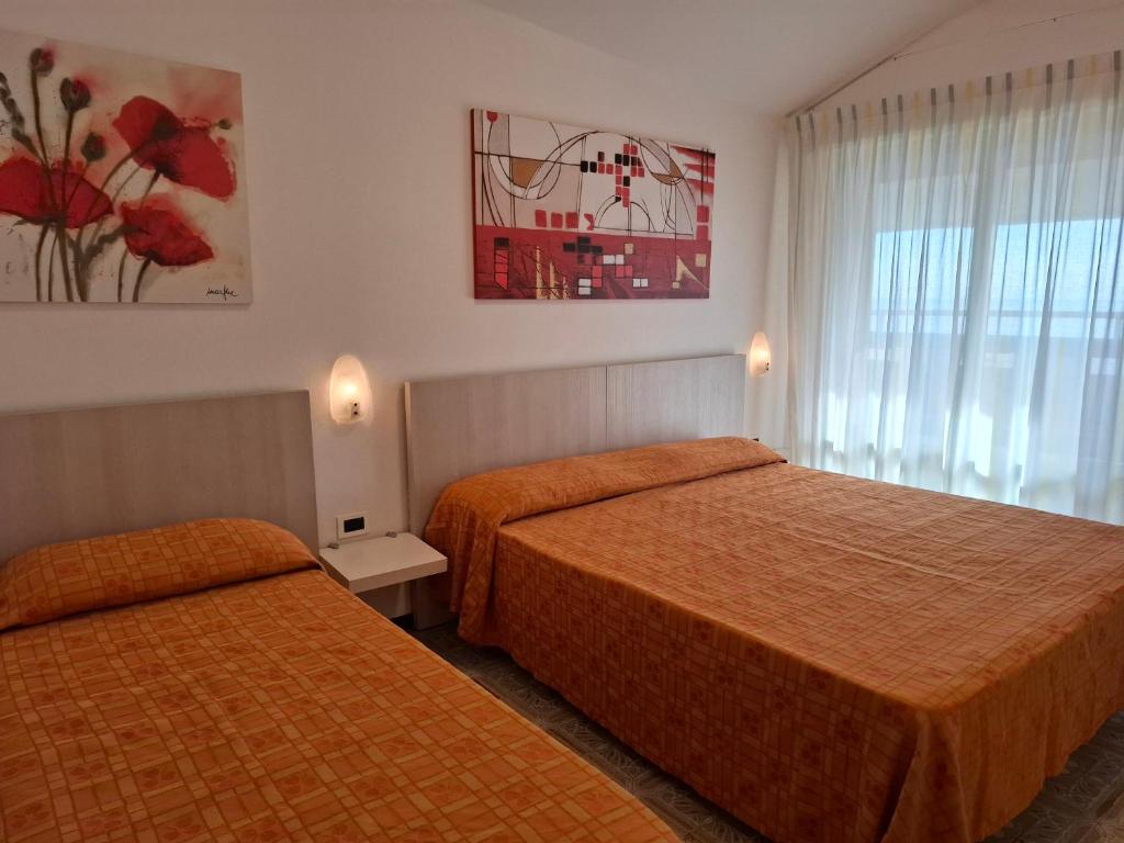 une chambre d'hôtel avec deux lits et une fenêtre dans l'établissement Residence Zenith, à Caorle 68 autres photos