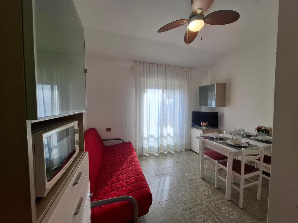 un salon avec un canapé rouge et une télévision dans l'établissement Residence Zenith, à Caorle