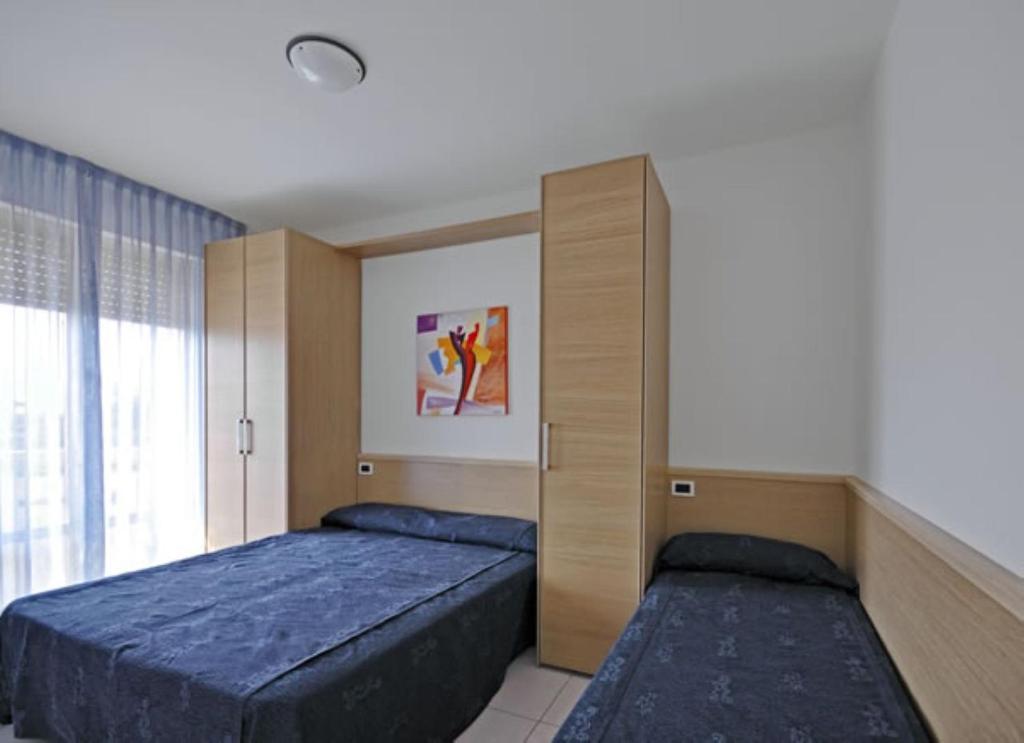 - une chambre avec un lit et une armoire intégrée dans l'établissement Residence Zenith, à Caorle