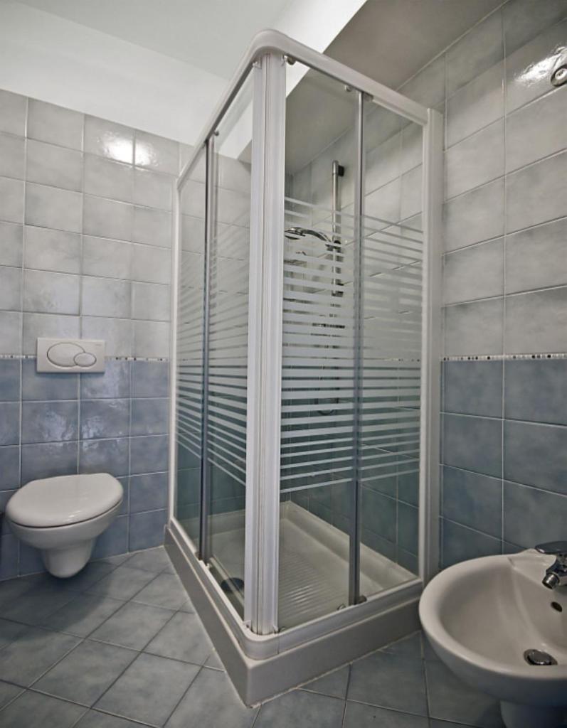 une salle de bain avec une douche, des toilettes et un lavabo dans l'établissement Residence Zenith, à Caorle