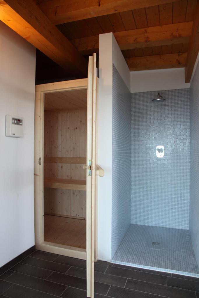 une douche avec une porte vitrée dans une salle de bain dans l'établissement Hotel Bellevue, à Lignano Sabbiadoro