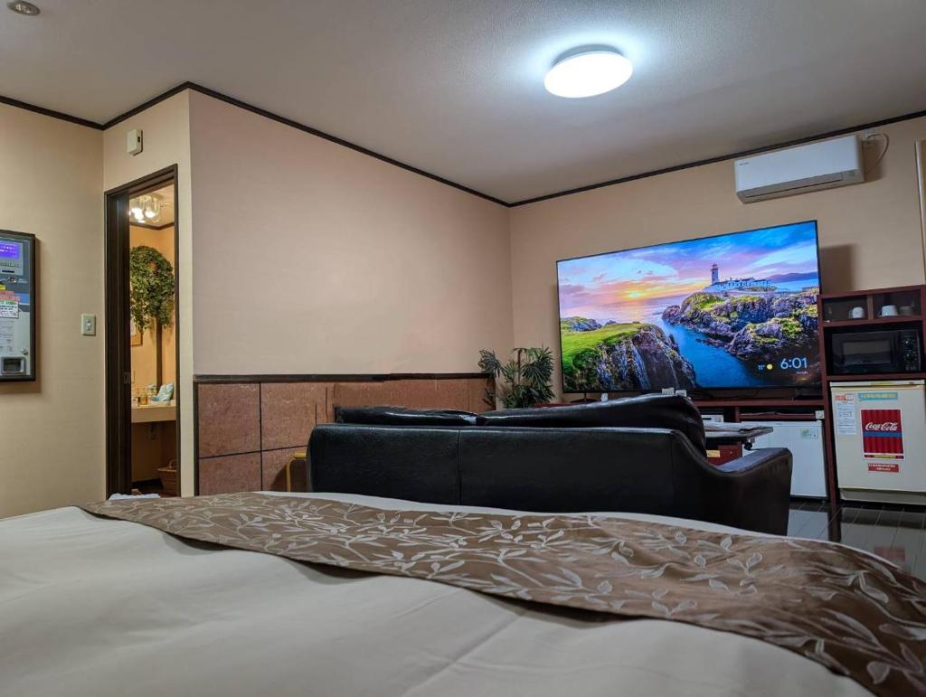 - une chambre avec un lit et un grand écran dans l'établissement ホテル ツインビー, à Yabase