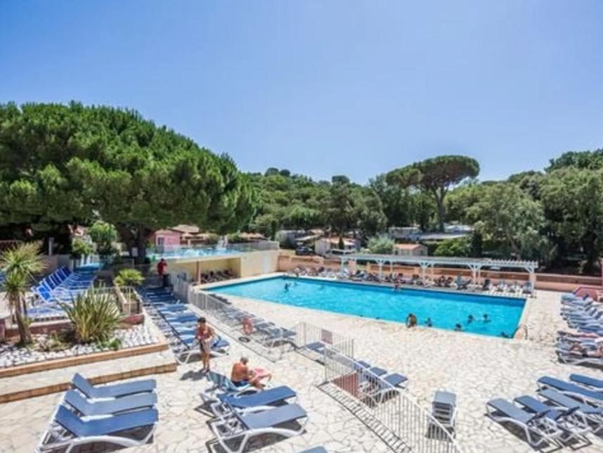 une grande piscine avec des chaises longues et une piscine dans l'établissement Mobilhome résidentiel, à Gassin