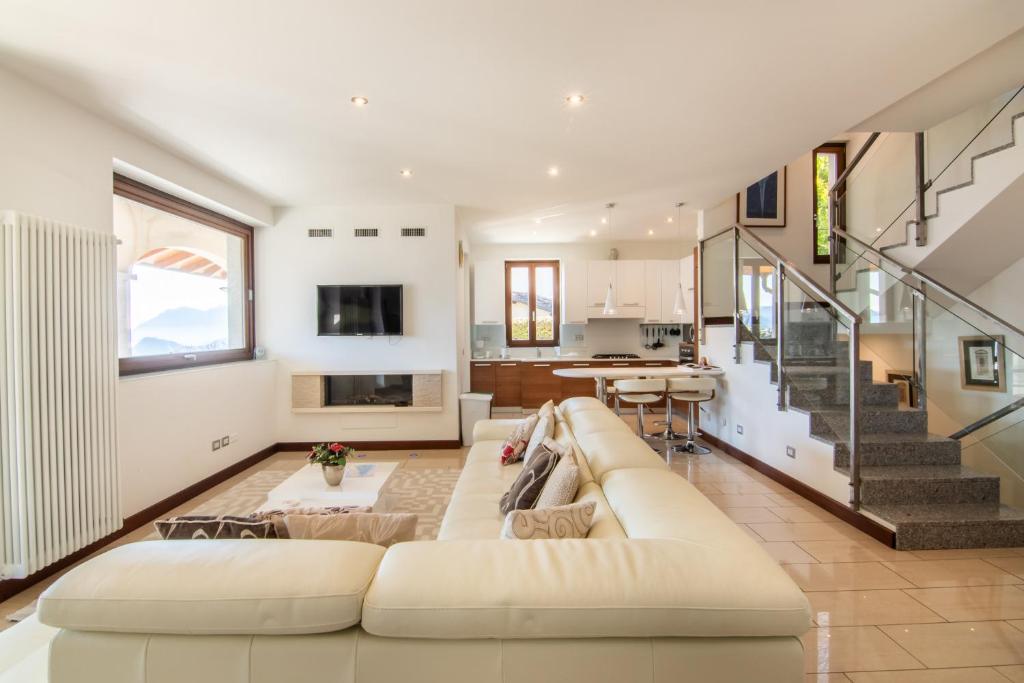 - un salon avec un canapé blanc et un escalier dans l'établissement Villa Lumbini, à Plesio