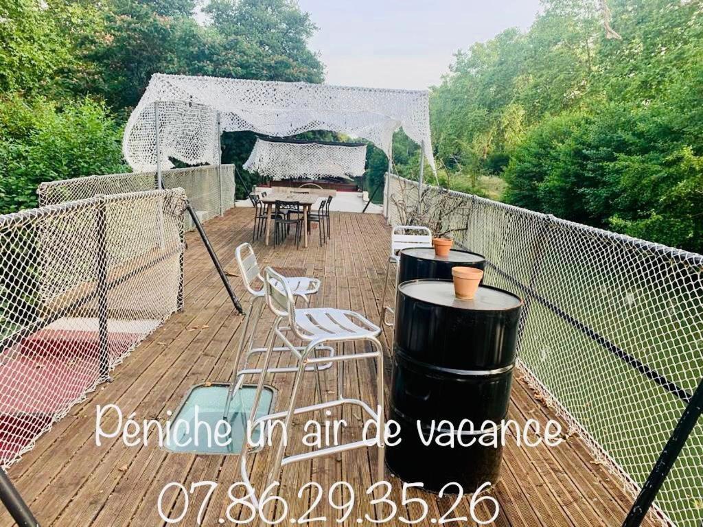 une terrasse avec une table, des chaises et un grill dans l'établissement chambres dans peniche un air de vacances, à Toulouse